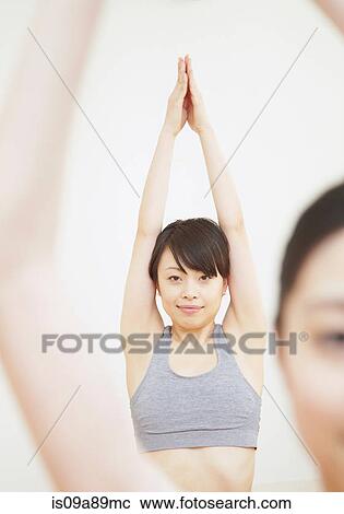 Stock Image - Woman with arms raised and hands together. Fotosearch