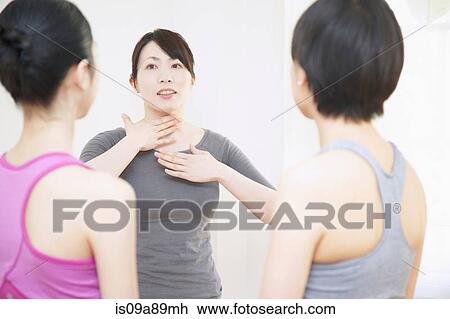 Stock Image - Yoga teacher demonstrating to young women. Fotosearch