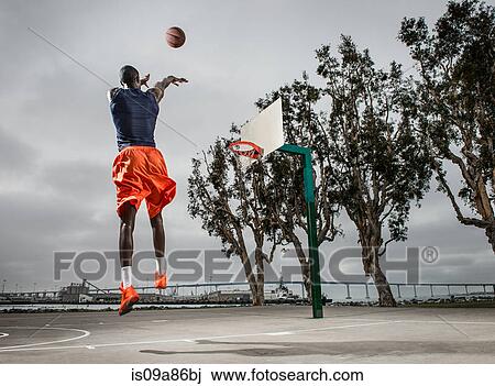 Young basketball player jumping to score View Large Photo Image Stock Image - Young basketball player jumping to score. Fotosearch