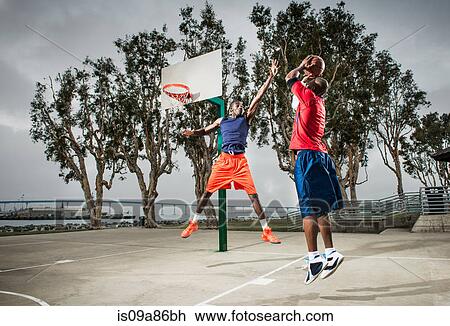 Young basketball players jumping to score hoop View Large Photo Image Stock Image - Young basketball players jumping to score hoop. Fotosearch