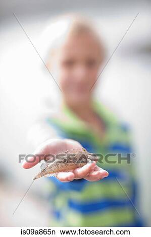 Picture - Young boy with small fish in hand. Fotosearch