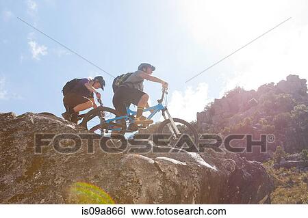 Young couple on mountain bikes on rocks View Large Photo Image Stock Image - Young couple on mountain bikes on rocks. Fotosearch
