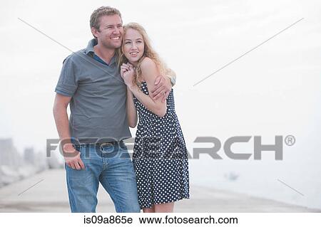 Young couple standing together on pier View Large Photo Image Stock Image - Young couple standing together on pier. Fotosearch