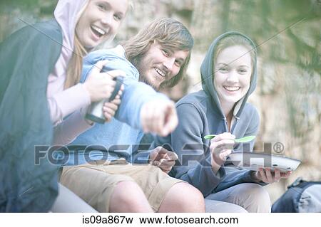 Stock Photo - Young group of people eating and drinking outdoors. Fotosearch