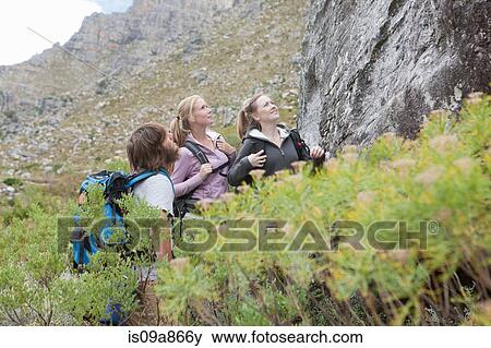 Stock Photo - Young hikers looking up at rock. Fotosearch