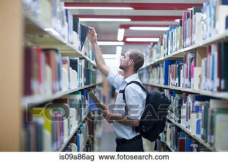 Young man holding clipboard in library View Large Photo Image Stock Image - Young man holding clipboard in library. Fotosearch