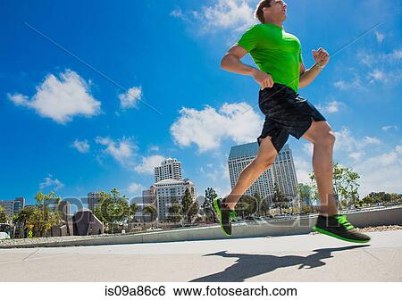 Young man jogging in city View Large Photo Image Stock Photograph - Young man jogging in city. Fotosearch