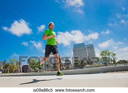 Stock Photography - Young man jogging in city. Fotosearch