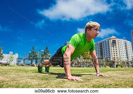 Young man performing push up in city park View Large Photo Image Stock Image - Young man performing push up in city park. Fotosearch