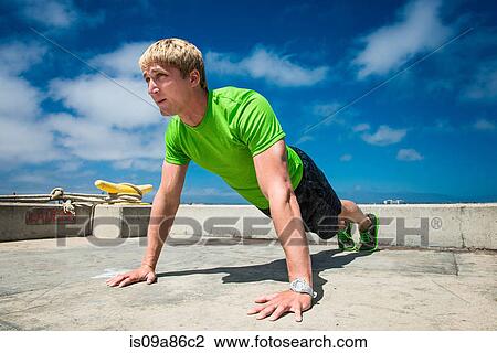 Young man performing push ups on pier View Large Photo Image Stock Image - Young man performing push ups on pier. Fotosearch