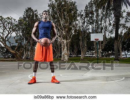 Young man playing basketball on court, portrait View Large Photo Image Stock Photography - Young man playing basketball on court, portrait. Fotosearch