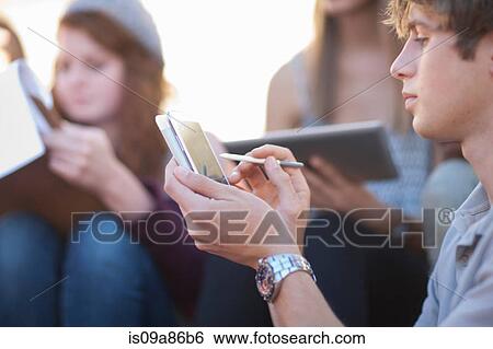 Young man using digital tablet View Large Photo Image Stock Photograph - Young man using digital tablet. Fotosearch