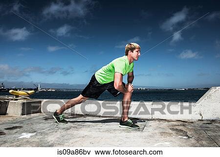 Stock Photo - Young man warming up before exercise. Fotosearch