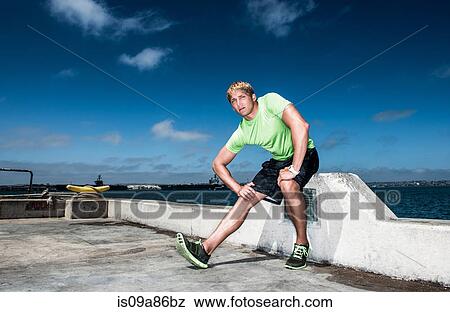 Young man warming up before exercise View Large Photo Image Stock Photo - Young man warming up before exercise. Fotosearch