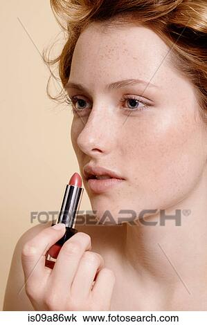 Young woman applying lipstick, close up View Large Photo Image Stock Image - Young woman applying lipstick, close up. Fotosearch