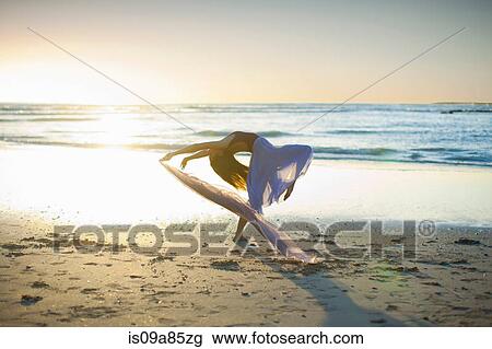 Young woman dancing on sunlit beach View Large Photo Image Stock Image - Young woman dancing on sunlit beach. Fotosearch
