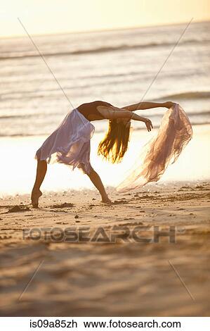 Young woman dancing on sunlit beach View Large Photo Image Stock Image - Young woman dancing on sunlit beach. Fotosearch