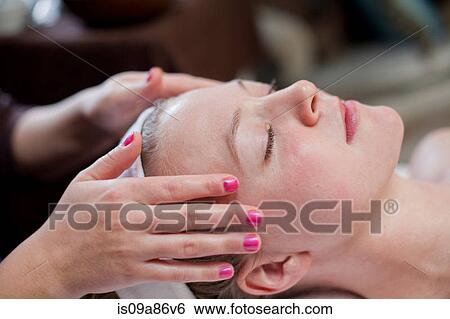 Stock Photograph - Young woman having facial treatment. Fotosearch