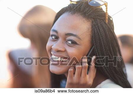 Picture - Young woman on cell phone, smiling. Fotosearch