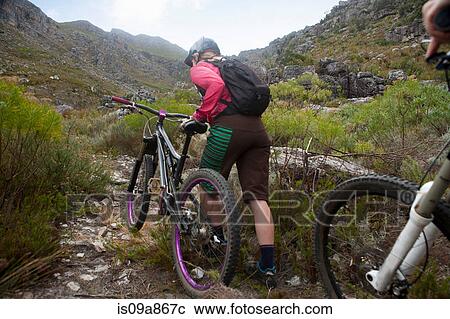 Young woman pushing mountain bike up mountain path View Large Photo Image Stock Image - Young woman pushing mountain bike up mountain path. Fotosearch