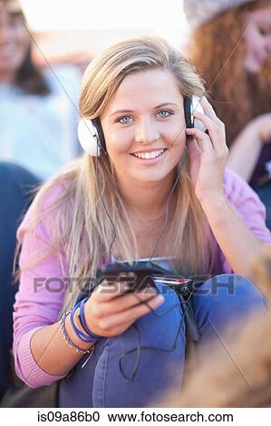 Stock Image - Young woman wearing headphones. Fotosearch