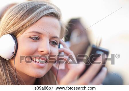 Stock Photo - Young woman wearing headphones. Fotosearch
