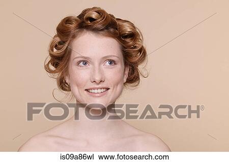 Young woman with curly red hair looking away and smiling View Large Photo Image Stock Image - Young woman with curly red hair looking away and smiling. Fotosearch