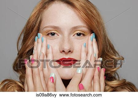 Stock Photo - Young woman with three sets of hands touching her cheeks. Fotosearch