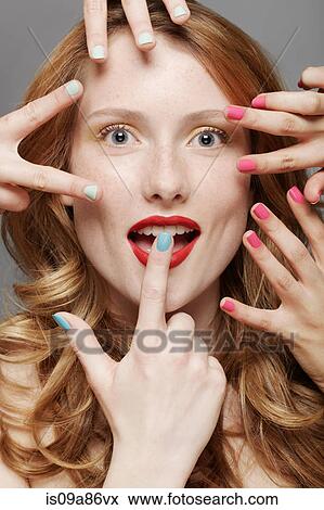 Young woman with wide eyes surrounded by fingers wearing nail varnish View Large Photo Image Stock Photo - Young woman with wide eyes surrounded by fingers wearing nail varnish. Fotosearch