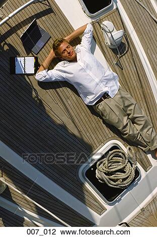 Stock Image - Man on sailing boat. Fotosearch