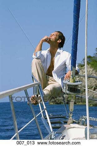 Stock Image - Man on sailing boat. Fotosearch