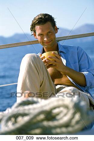 Stock Photo - Man on sailing boat. Fotosearch