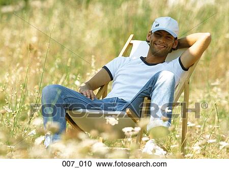 Man reclining on deck chair View Large Photo Image Stock Image - Man reclining on deck chair. Fotosearch