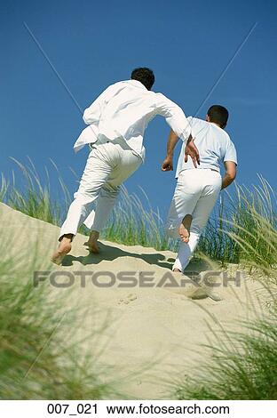 Men running in the dunes View Large Photo Image Stock Image - Men running in the dunes. Fotosearch