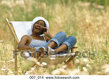 Picture - Woman reclining on deck chair. Fotosearch