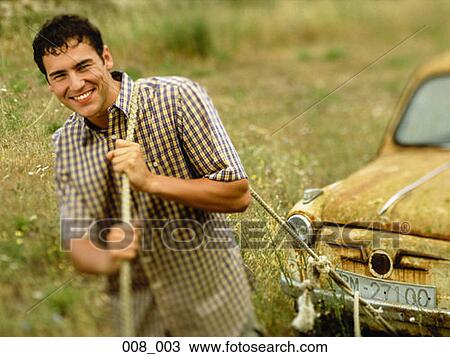 Stock Image - Man pulling car. Fotosearch