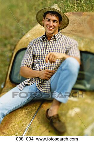 Man sitting on car View Large Photo Image Picture - Man sitting on car. Fotosearch