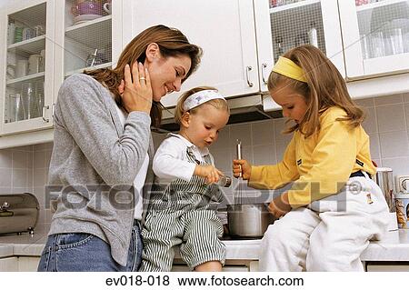 Mother and daughters in kitchen View Large Photo Image Stock Photo - Mother and daughters in kitchen. Fotosearch