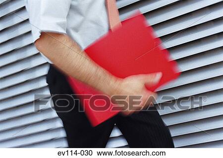 Stock Image - Man carrying file. Fotosearch