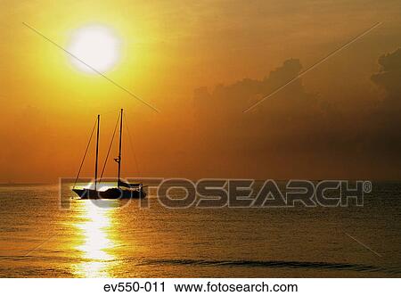 Stock Image - Sailing boat in sunset. Fotosearch