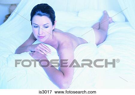 Woman lying on bed View Large Photo Image Stock Photo - Woman lying on bed. Fotosearch