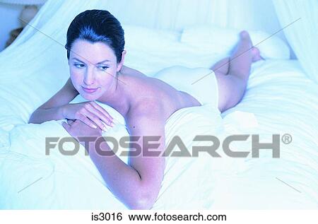Woman lying on bed View Large Photo Image Stock Photograph - Woman lying on bed. Fotosearch