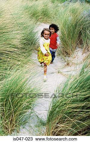 Boy and girl playing on a beach View Large Photo Image Stock Image - Boy and girl playing on a beach. Fotosearch