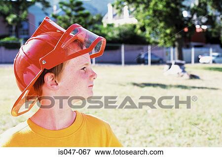 Boy wearing a fireman helmet View Large Photo Image Stock Photo - Boy wearing a fireman helmet . Fotosearch