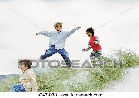 Boys playing on a dune View Large Photo Image Stock Image - Boys playing on a dune. Fotosearch