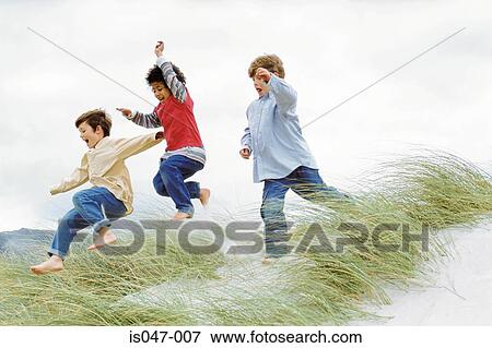Boys playing on a dune View Large Photo Image Stock Photo - Boys playing on a dune. Fotosearch
