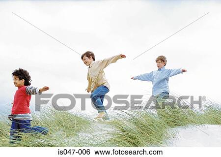 Boys playing on a dune View Large Photo Image Stock Photograph - Boys playing on a dune. Fotosearch
