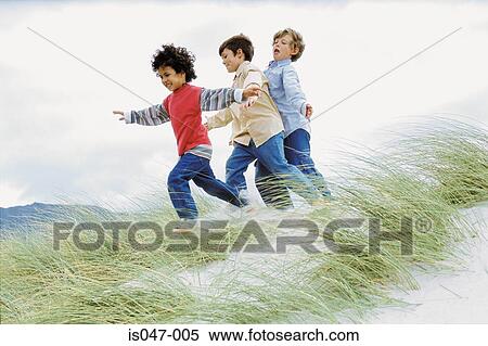 Boys playing on a dune View Large Photo Image Stock Photography - Boys playing on a dune. Fotosearch