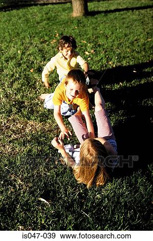 Kid playing on the grass View Large Photo Image Stock Photo - Kid playing on the grass. Fotosearch
