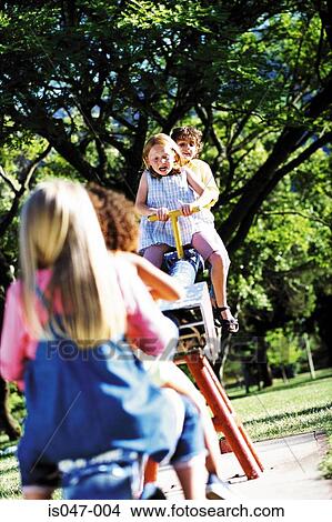 Kids on a see-saw View Large Photo Image Picture - Kids on a see-saw. Fotosearch